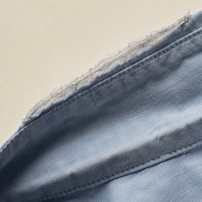 The worn-through outer fold of a cotton shirt collar in close-up.