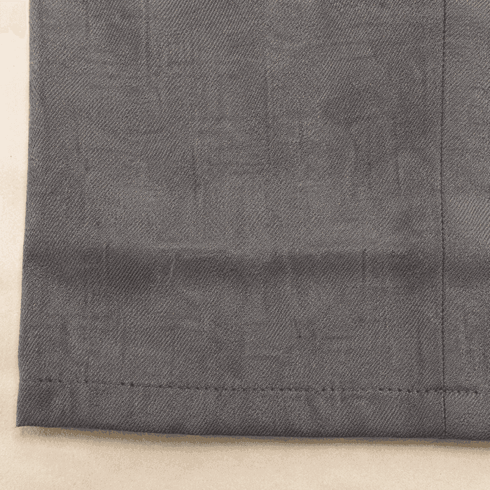 An old let-down hemline crease running across grey wool trouser cloth.