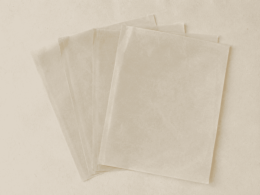 Four sheets of blank translucent pattern tissue fanned out in a loose stack.